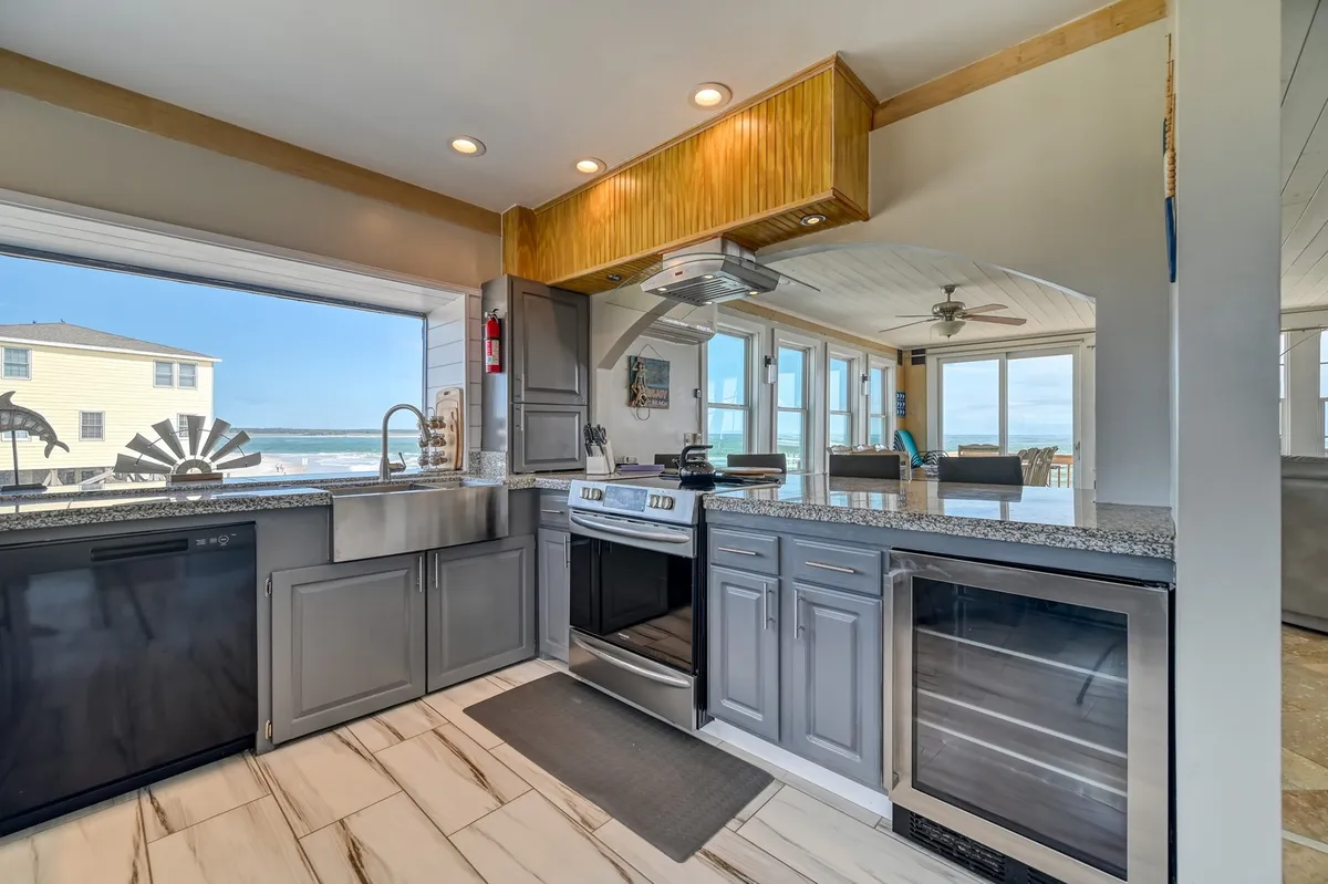 A modern kitchen outfitted with granite countertops, stainless steel appliances, and a large window overlooking the water. The open layout and bright, airy ambiance set the stage for culinary adventures and socializing.
